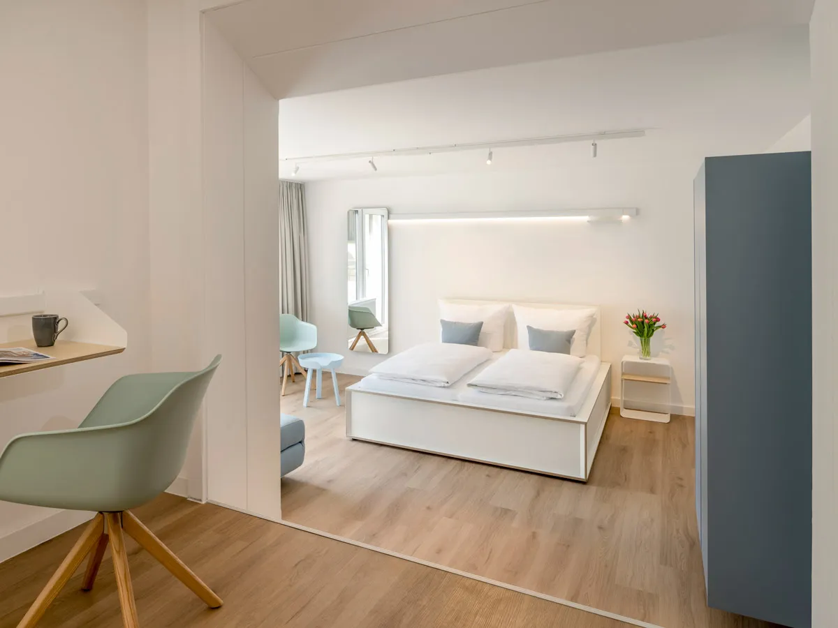 Blick vom Arbeitsplatz ins Schlafzimmer mit beleuchteter Wandleiste